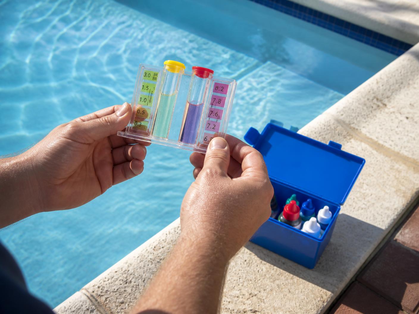 Kit de análisis con muestras de agua para medir cloro y pH al borde de una piscina