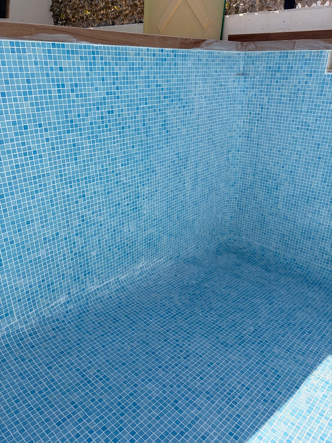 Detalle del revestimiento de gresite y las juntas en una piscina vacía