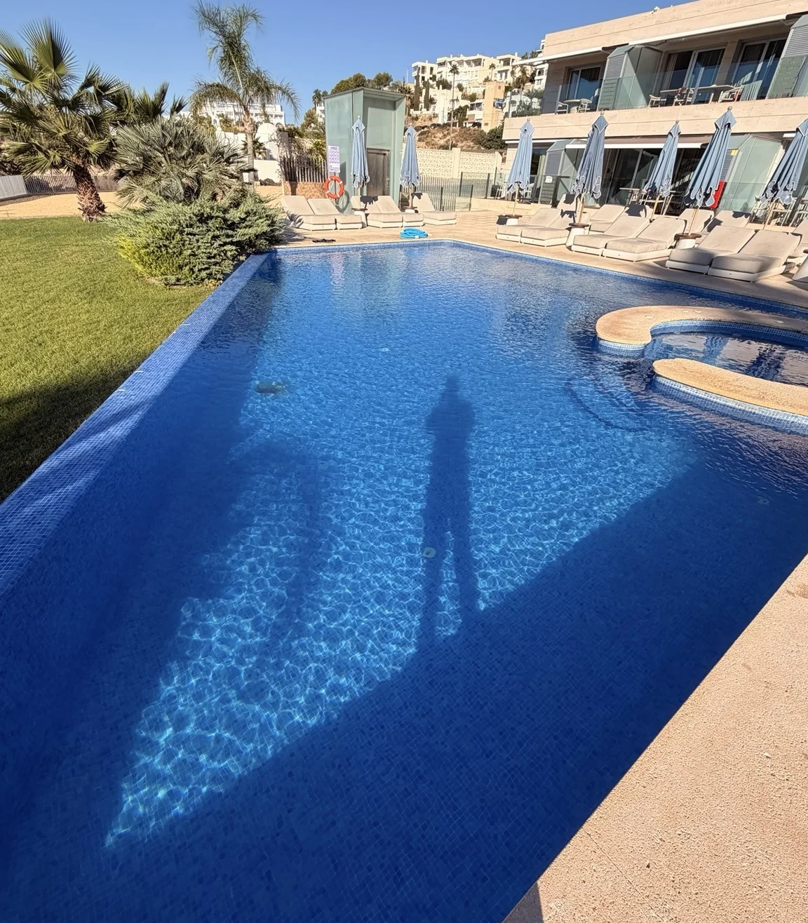 Piscina junto a una zona de tumbonas y alojamientos